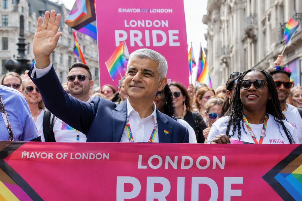 Sadiq Khan attending London Pride with rainbow flags and Mayor of London signage.