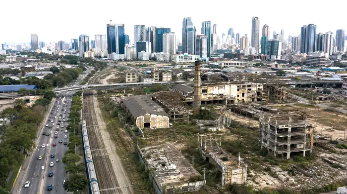 Abandoned industrial infrastructure contrasting with an active urban economy in Uruguay.