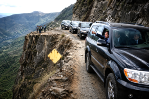 Government convoy advancing toward a dangerous cliff despite visible warning signs.