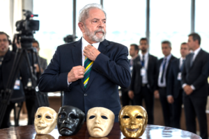 Political leader standing before theatrical masks symbolizing ideological transformation and strategic repositioning.