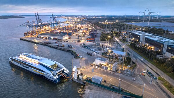 Electric ferry charging at a modern port alongside energy infrastructure and data centers.