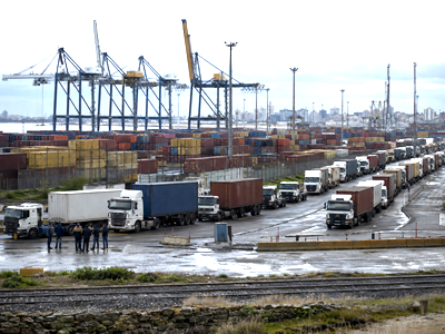 Idle cranes, cargo containers and halted trucks at the Port of Montevideo during a labor disruption.