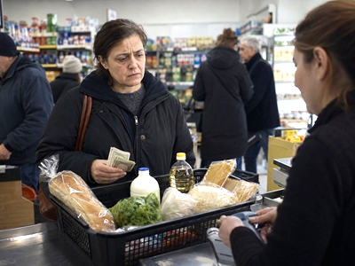 Shopper facing everyday purchasing choices at a grocery checkout amid declining purchasing power.