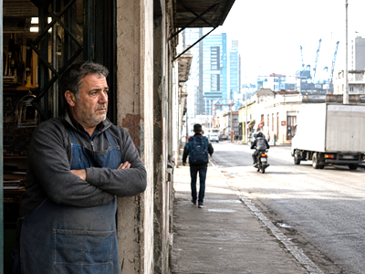 Small business owner in Montevideo amid contrasting signs of economic inertia and modernization.
