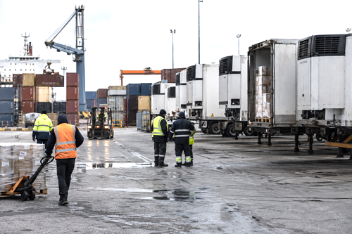 Workers and refrigerated freight infrastructure near Montevideo illustrating pressure on Uruguay’s productive and export sectors.