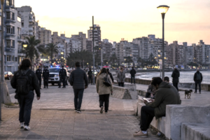 Residents in an urban neighborhood in Uruguay with a police patrol in the background, illustrating the debate over security and democratic limits.