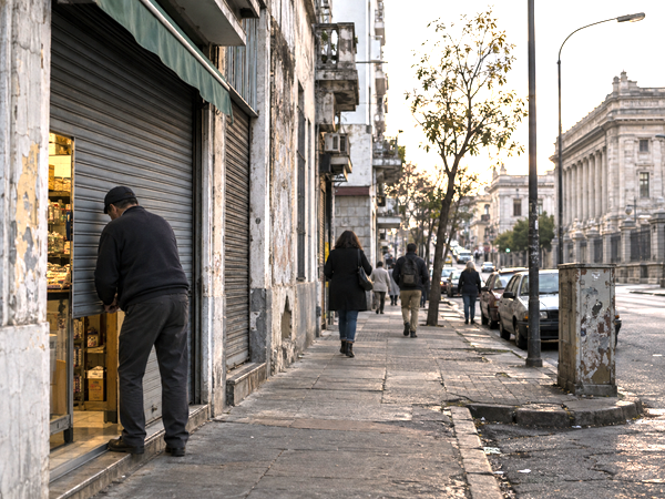 Small business owner closing a neighborhood shop on a Montevideo street at the end of the workday.
