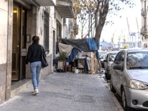Montevideo resident facing an obstructed sidewalk and parked car in an everyday urban scene.