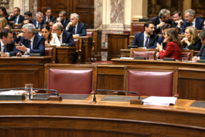 Two empty seats in a parliamentary chamber symbolizing political inconsistency and strategic absence during a vote.